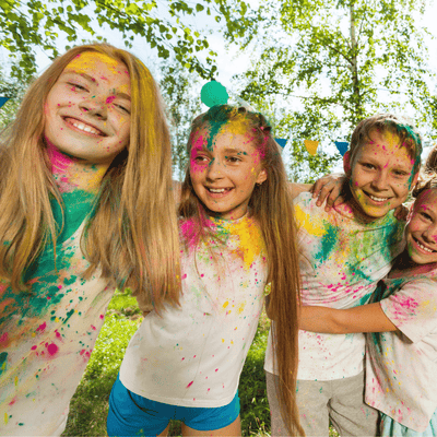 Kids wearing white t-shirts covered with color powder