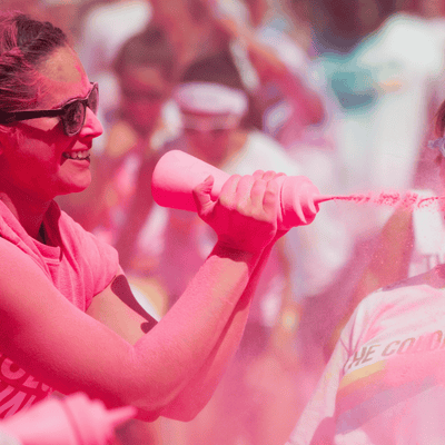 Someone squeezing a bottle filled of colour powder